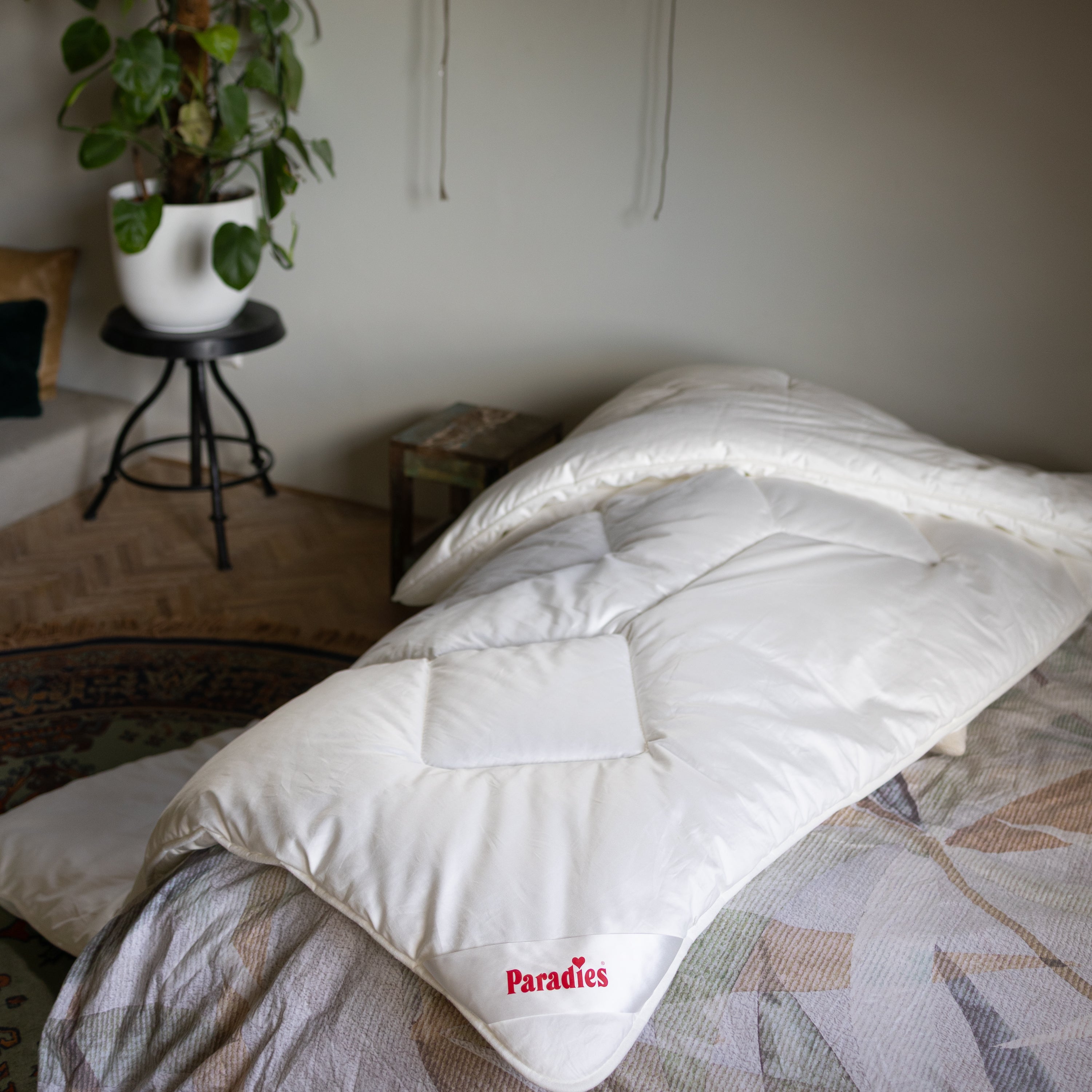 Nahaufnahme der Paradies Prima Ganzjahresbettdecke, die vom Bett auf den Teppich herunter hängt