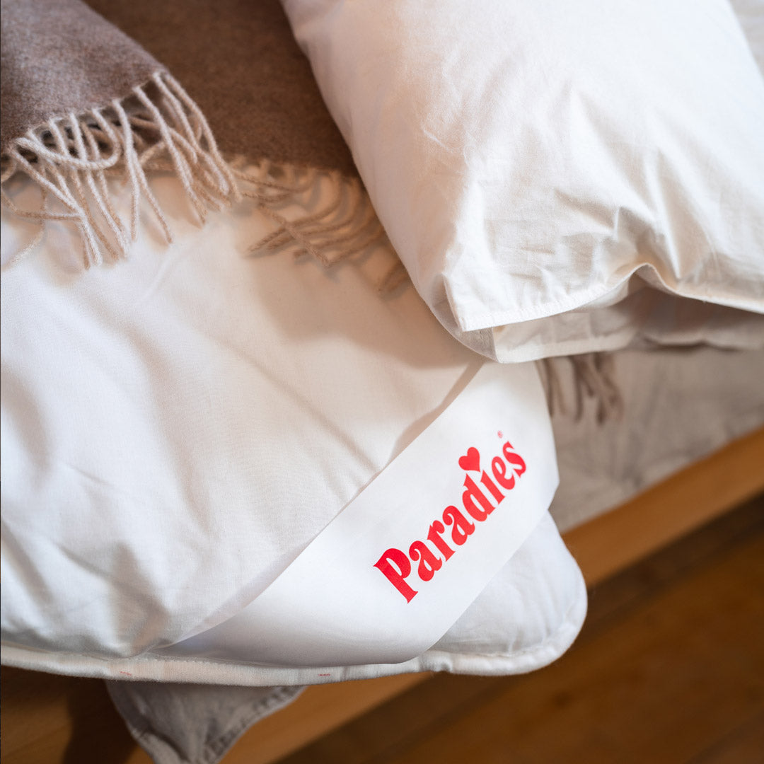 Paradies Ganzjahresdecke auf einem gemütlichen Bett mit einer Baumwolldecke zugedeckt