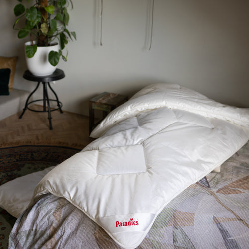 Nahaufnahme der Paradies Prima Ganzjahresbettdecke, die vom Bett auf den Teppich herunter hängt